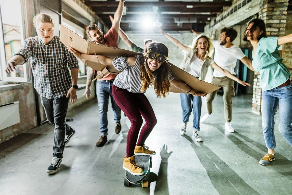 woman skateboarding with other people cheering behind her