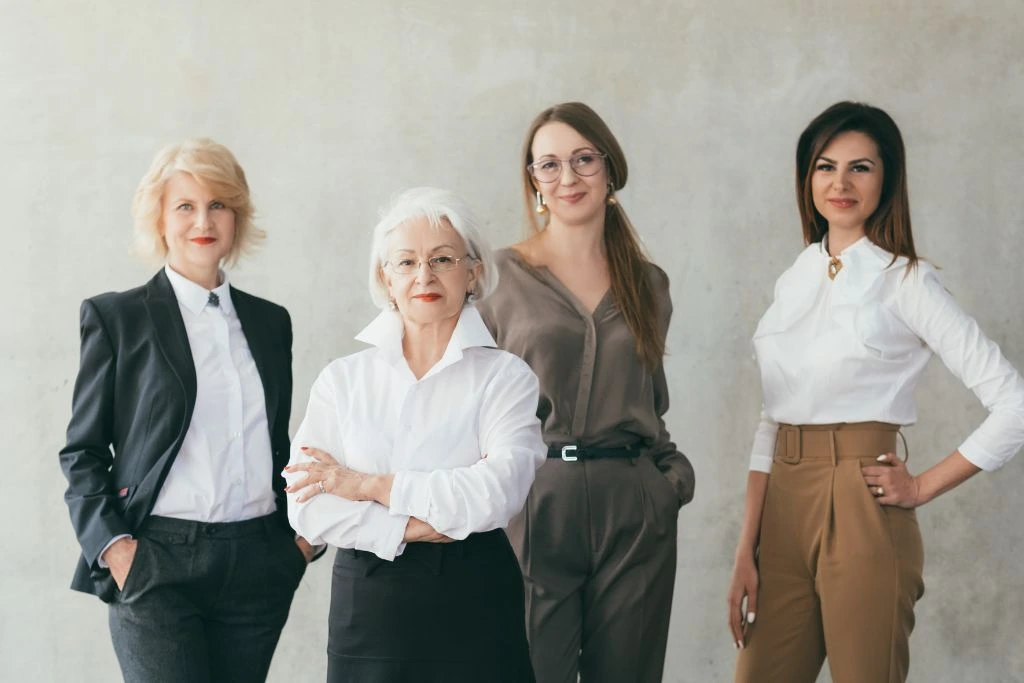 A group of women standing on a greyish background