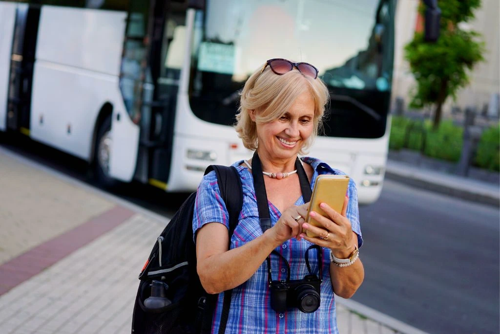 An old woman using a travel mobile application for her adventure