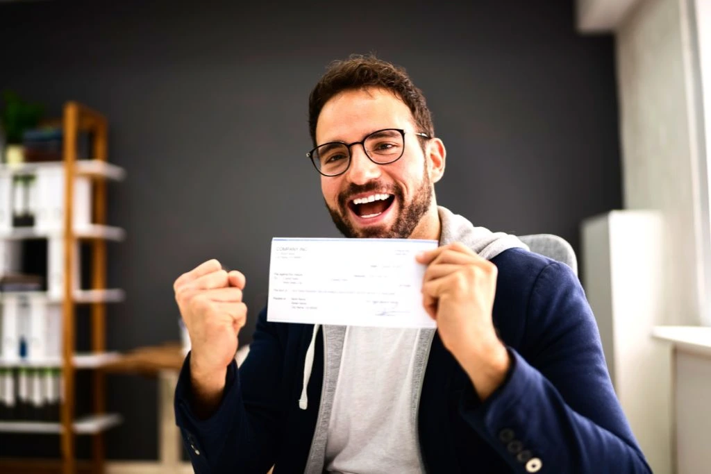 happy man holding a paycheck