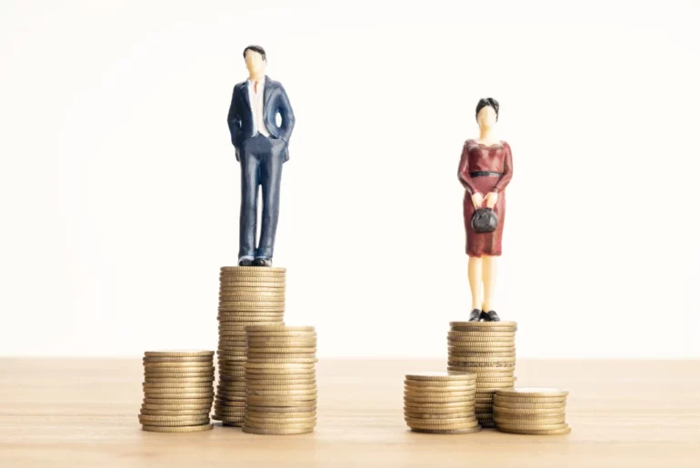 a man and a woman figurines on top of separate stacks of coins