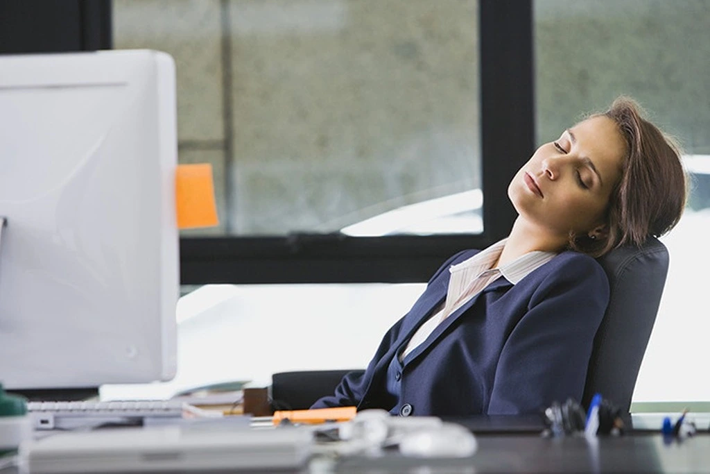 A corporate woman sleeping on an office chair