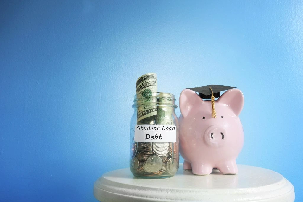 A piggy bank beside a jar of paper bills and coins