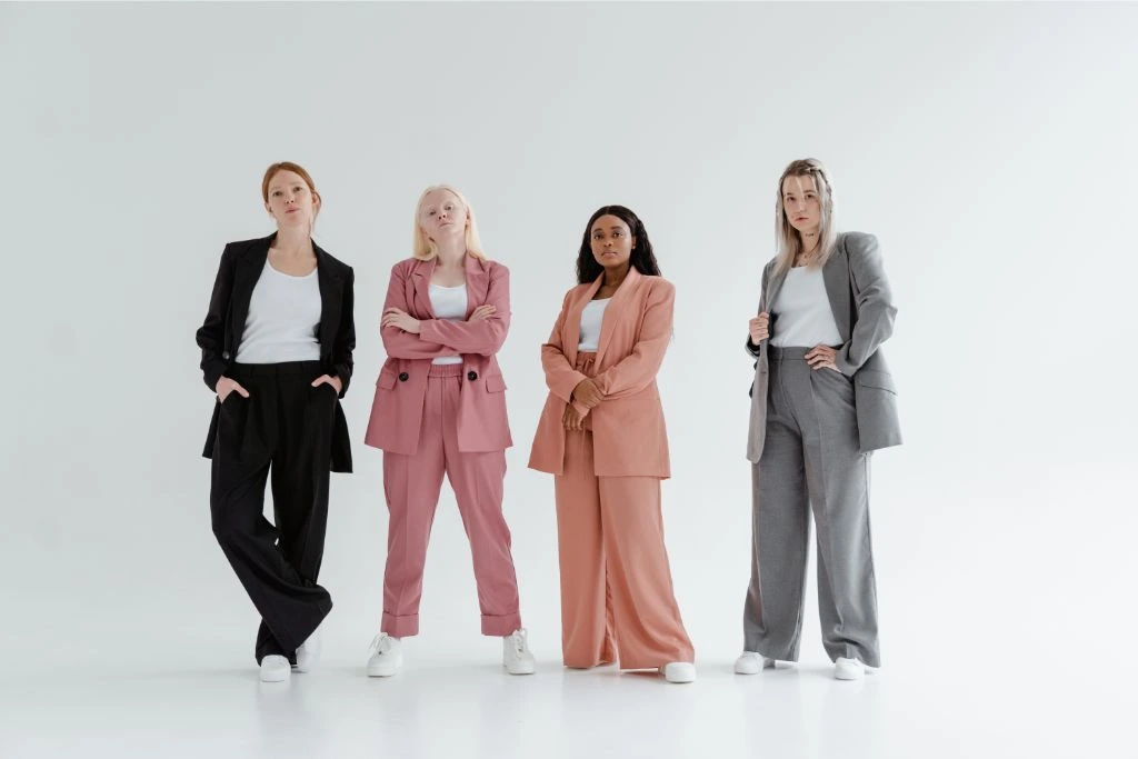 four women wearing colorful and baggy suits