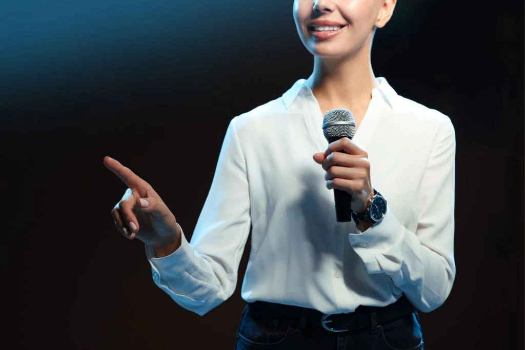 A person holding a microphone and pointing at something
