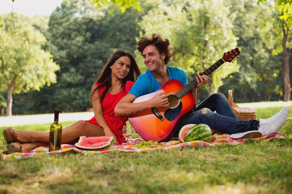 A man and a woman are having a picnic on the grass
