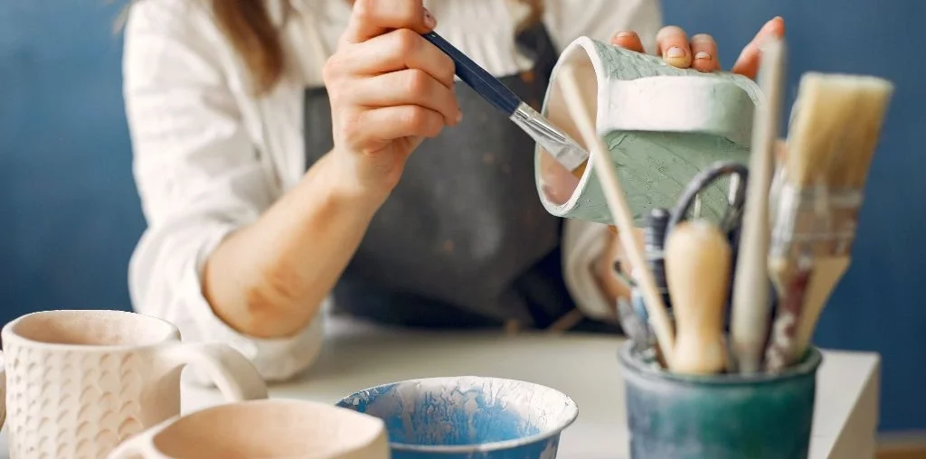 A woman painting a cup