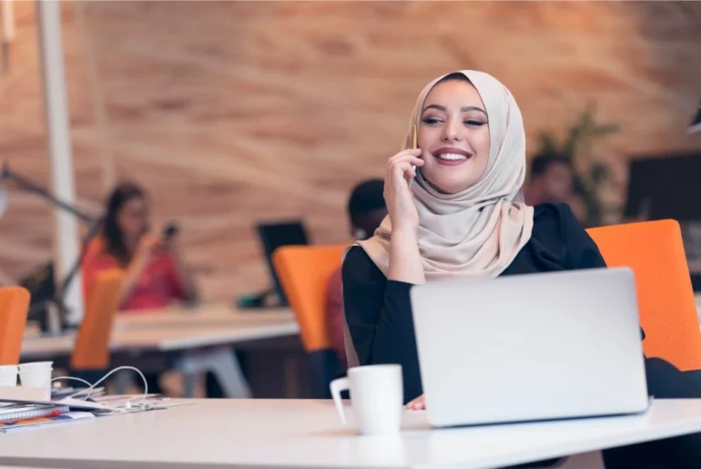 woman wearing a hijab sitting at her desk