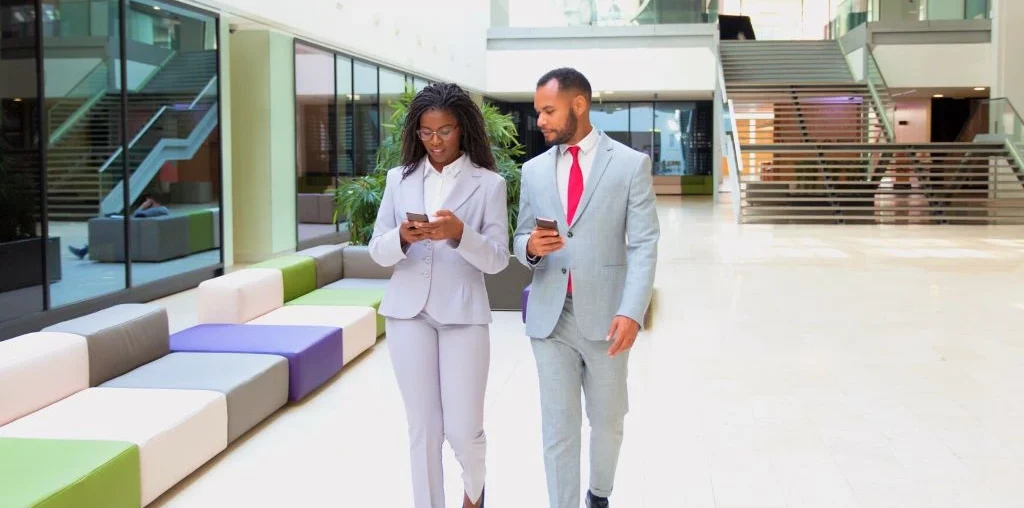 professional looking male and female employees walking together inside their office building