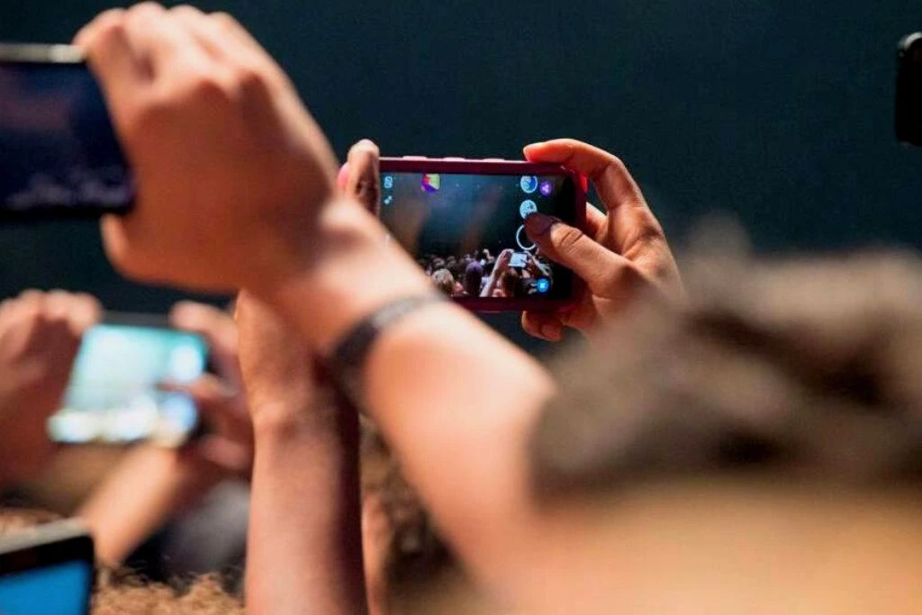 People Holding cellphones while video recording