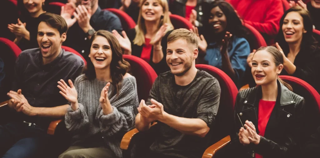 theater audience clapping and smiling