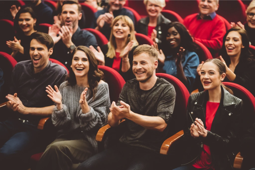 theater audience clapping and smiling