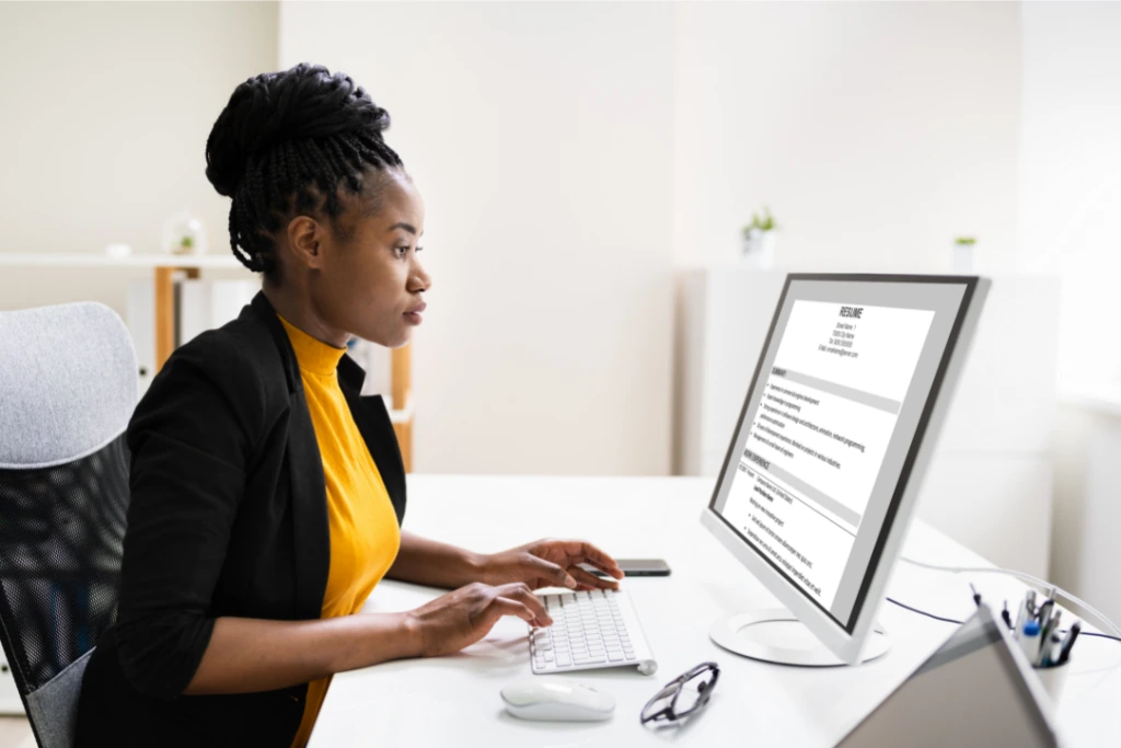 woman in front of a computer creating a resume