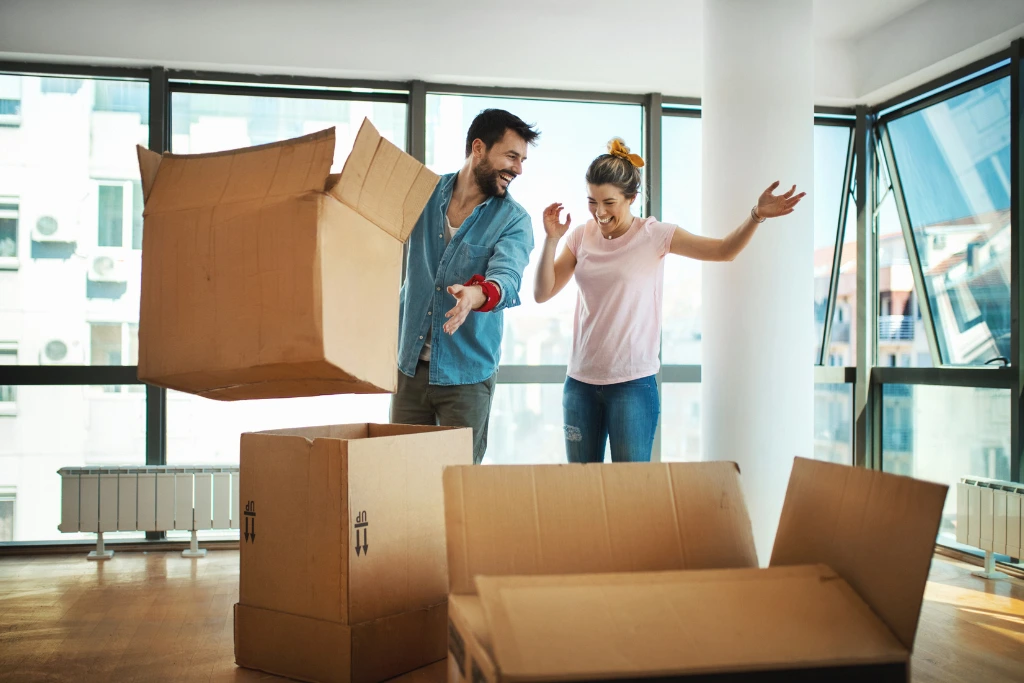 couple moving to a new place with boxes around them