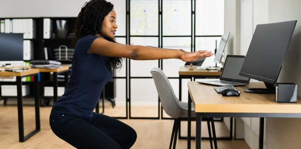 woman exercising in front of her desk