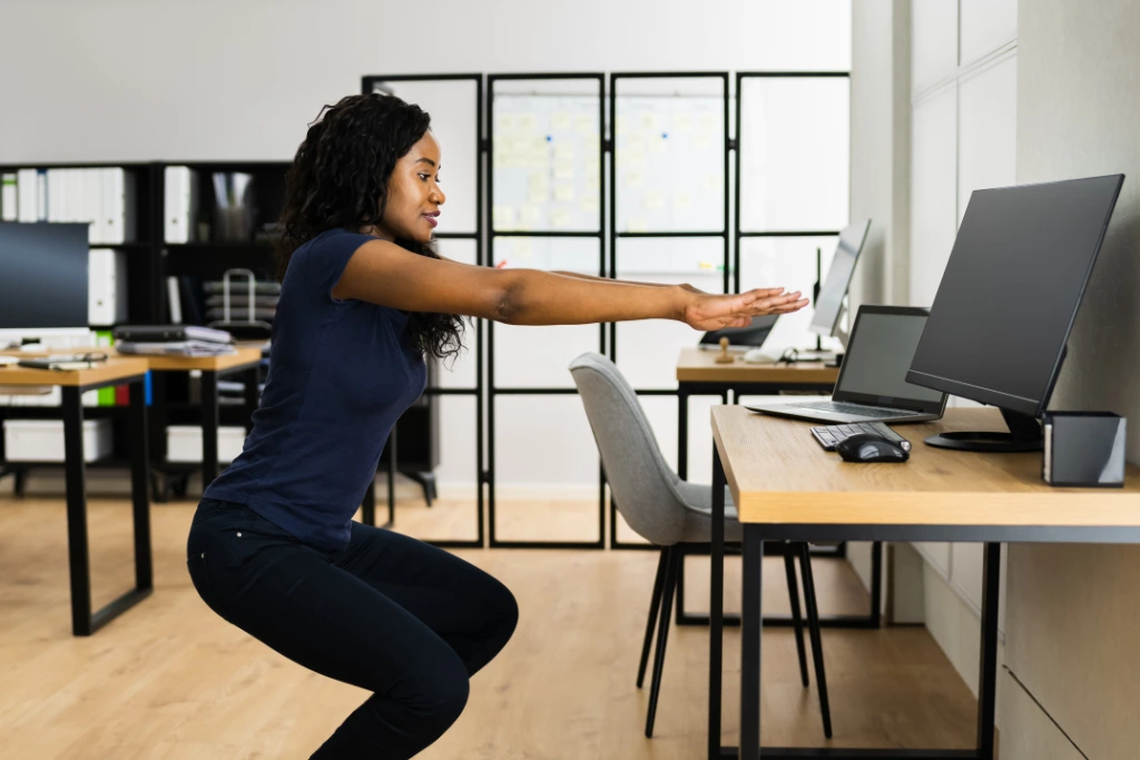 woman exercising in front of her desk