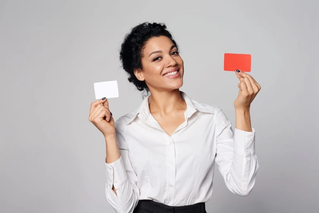Woman smiling while holding 2 cards