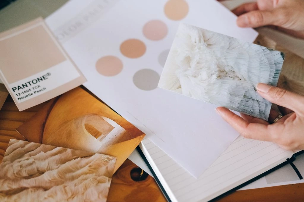 A photo showing a person's hand choosing and comparing shades of color on a palette.