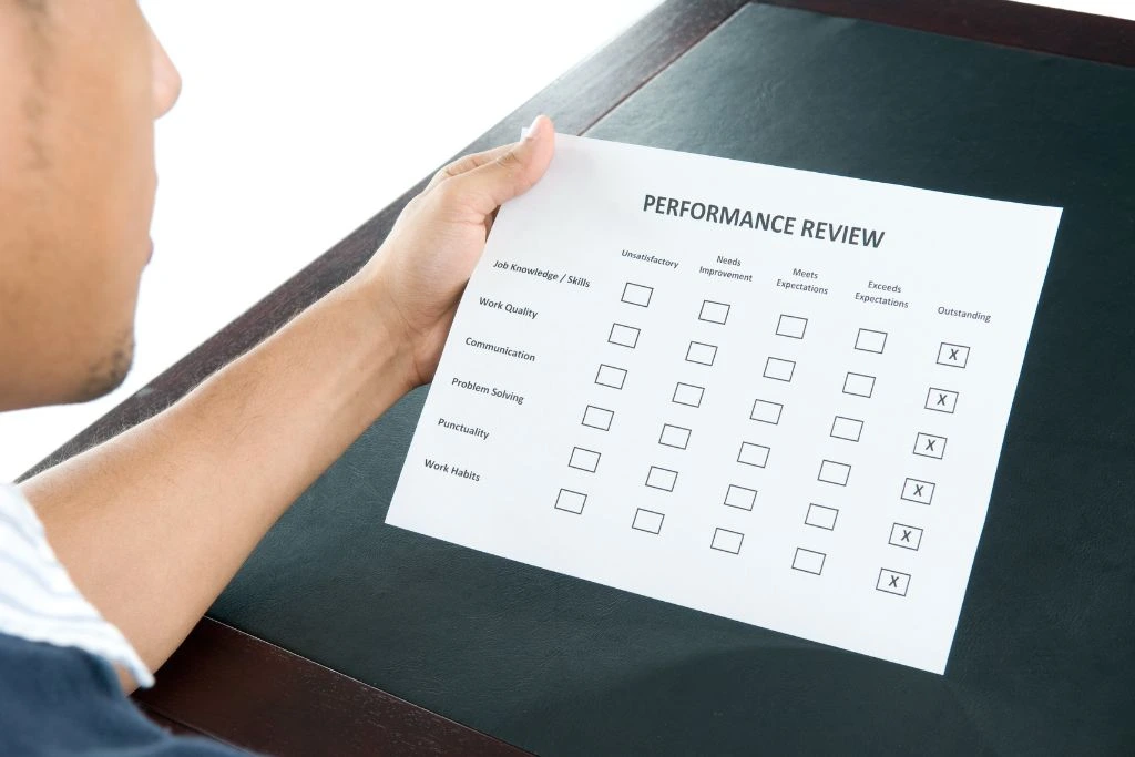A man holding a checklist of a performance review paper.