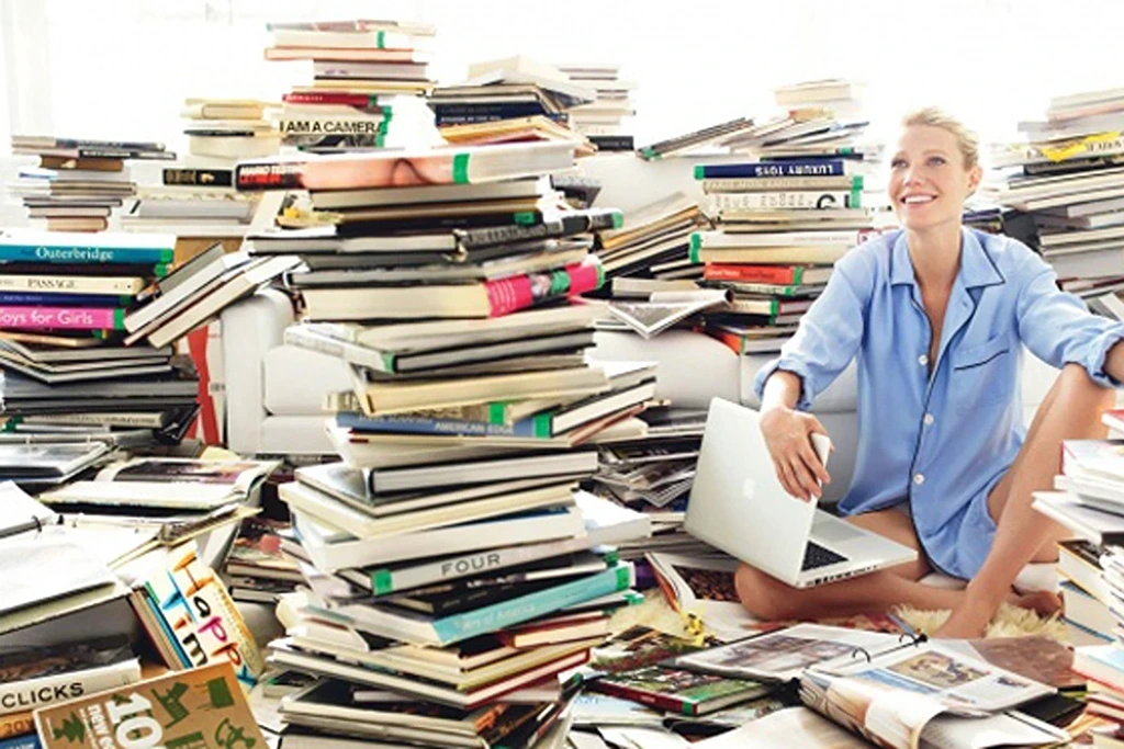 a woman with a huge pile of books