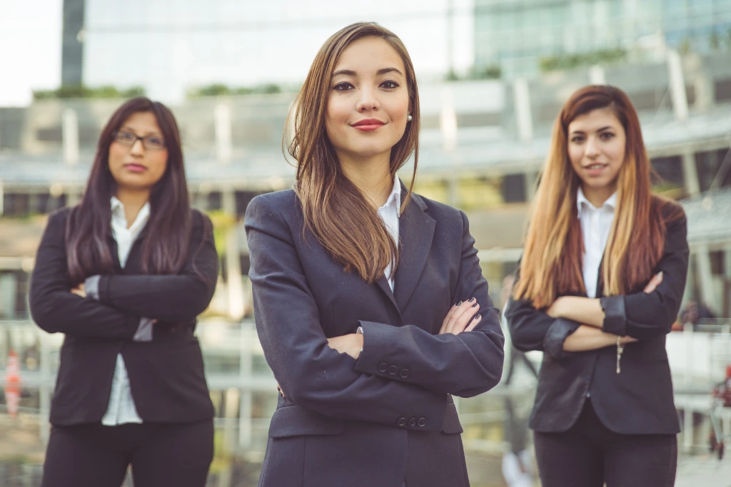 three women power posing while wearing office clothes