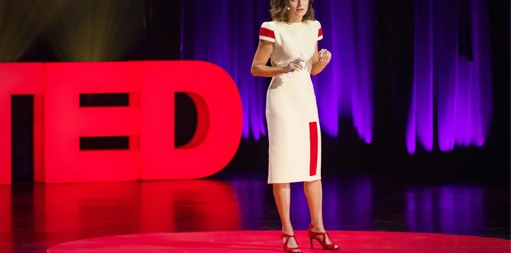 woman standing on tedtalk stage and sharing her speech